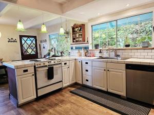 a large kitchen with white appliances and windows at Sky Cabin in Aptos