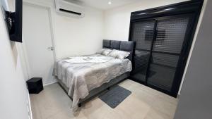 a bedroom with a bed in a white room at Royal ID Setor Oeste in Goiânia +35 photos