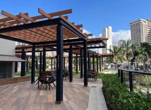 a wooden pergola with tables and chairs on a patio at Royal ID Setor Oeste in Goiânia