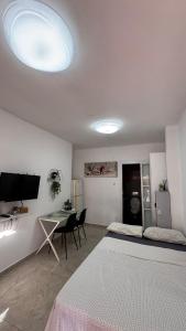a white room with a desk and a table with chairs at Eilat Room in Eilat