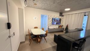 a kitchen and living room with a white table and chairs at Royal ID Setor Oeste in Goiânia
