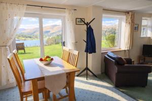 a living room with a table and a couch and a window at Grasmere View, stunning views over Grasmere Lake, ideal romantic break in Grasmere