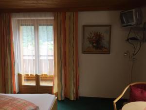 ein Schlafzimmer mit einem Fenster, einem Bett und einem TV in der Unterkunft Haus-Nummer 355 bei Renate & Roland in Pfunds
