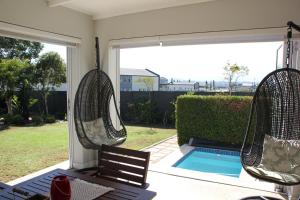 a patio with two swinging chairs and a pool at Logans Place in Oakdale