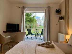 a bedroom with a bed and a view of a patio at Penzion Žírovice in Františkovy Lázně
