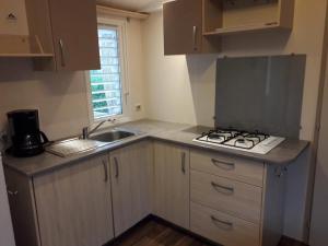 a small kitchen with a sink and a stove at Camping 3 étoiles - ccbfgdc in Neuvic