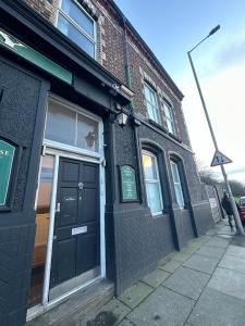 a building with a black door on a street at Melrose Abbey Guest House in Liverpool