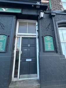 a black door of a building with signs on it at Melrose Abbey Guest House in Liverpool