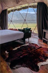 a bedroom with a bed and a large window with a rug at Tammah Jackson Hole in Wilson