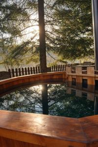 a bridge over a body of water with trees at Cabana Brazilor in Câmpina