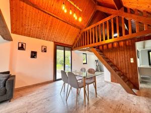 a dining room with a table and a wooden ceiling at La Campagnarde, Maison de campagne proche Bapaume in Flers