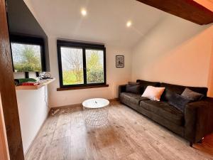 a living room with a couch and a table at La Campagnarde, Maison de campagne proche Bapaume in Flers
