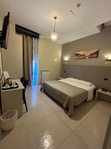 a bedroom with a bed and a desk and a television at Hotel 26 in Milan +27 photos