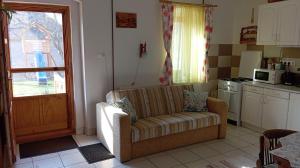 a living room with a couch and a kitchen at Sprencz Családi Major in Sátoraljaújhely