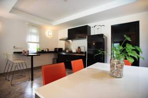 a kitchen with a table and orange chairs at Royal Shell by Utalay Koh Chang in Ban Khlong Son