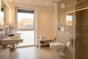 a bathroom with a shower and a toilet and a sink at Steverbett Hotel in Lüdinghausen +55 photos