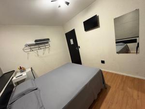 a bedroom with a bed and a television in it at Travessa 12 - Suítes centro de Serra Negra - SP in Serra Negra +76 photos