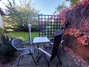 three chairs and a table on a patio at Ferienquartier T5 Bahnhofstraße 6 in Trassenheide
