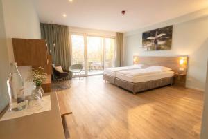 a hotel room with a bed and a desk and a room at Steverbett Hotel in Lüdinghausen