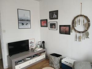 a living room with a flat screen tv on a white wall at Villa Joret in Fermanville
