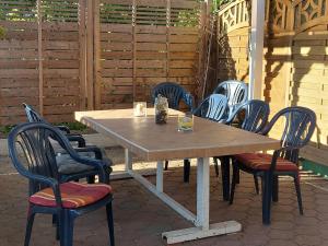 a wooden table with chairs around it with a drink on it at Ferienquartier T5 Bahnhofstraße 6 in Trassenheide