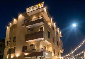 a tall building with a sign on it at night at The Stay Pyramids Inn in Cairo