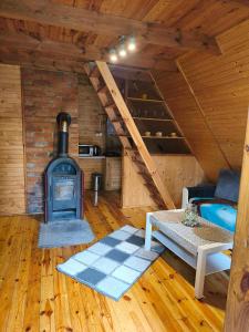 a room with a woodburning stove in a cabin at Zofiówka las in Zofiówka