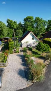 a house with a gravel driveway in a yard at "ZeeLandZon" Holiday home by the lake with Jacuzzi and Sauna in Herkingen