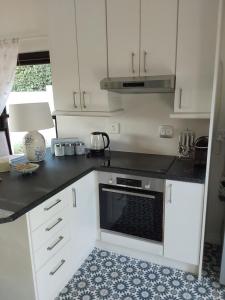 a kitchen with white cabinets and a stove top oven at Sunset View in Somerset West