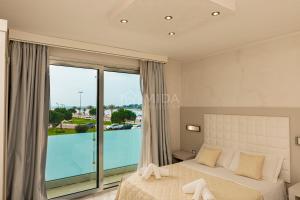 a bedroom with a bed and a large window at Riviera Luxury Rooms in Porto Cesareo