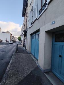 a building with blue doors on the side of a street at Charmant studio - Vanves in Vanves