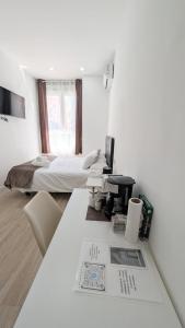 a white room with a bed and a desk with a table at Lofts IFEMA CH in Madrid
