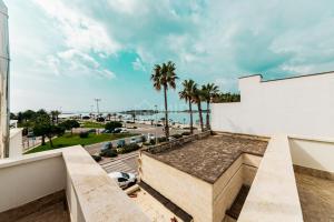 a view from the balcony of a building with palm trees at Riviera Luxury Rooms in Porto Cesareo