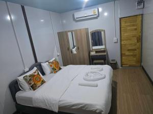 a bedroom with a large bed with towels on it at Avatar Resort Phangan Thailand in Ban Nua