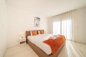 a bedroom with a large bed and a window at GuestReady - Aroeira Pool Villa in Setúbal