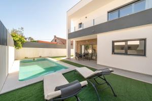 an image of a backyard with a swimming pool and a house at GuestReady - Aroeira Pool Villa in Setúbal