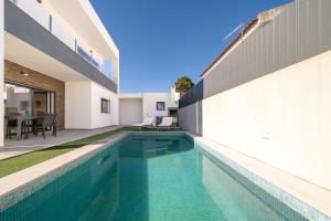 a swimming pool in the backyard of a house at GuestReady - Aroeira Pool Villa in Setúbal