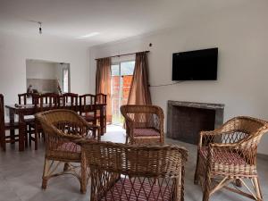 a living room with wicker chairs and a fireplace at Casa Bati in El Mollar