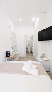 a white bedroom with a bed with towels on it at Lofts IFEMA CH in Madrid