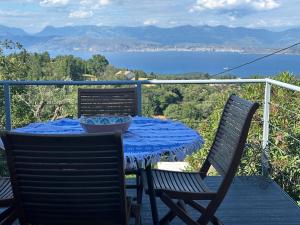 a table on a balcony with a view of the water at Tritzi house in Mesochórion