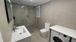 a bathroom with a sink and a washing machine at Apartamentos San Antonio - GrupoAMI in Ontinyent