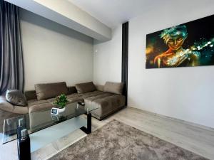 a living room with a couch and a glass table at Astryn Aparthotel 9 SELF CHECK-IN #Otopeni #Airport #Therme #Bucharest in Otopeni