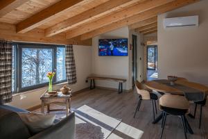 a living room with a table and chairs and a tv at Vigne en Ville in Aosta