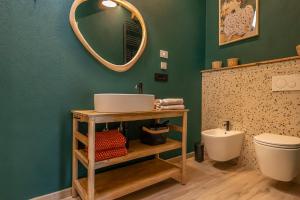a bathroom with a sink and a toilet and a mirror at Vigne en Ville in Aosta +22 photos