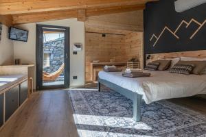 a bedroom with a large bed and a kitchen at Vigne en Ville in Aosta