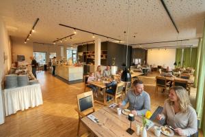 a group of people sitting at tables in a restaurant at Steverbett Hotel in Lüdinghausen