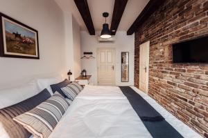 a bedroom with a large bed and a brick wall at Pension Zwicker in Prešov