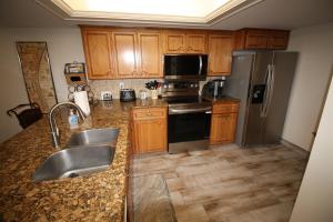 a kitchen with wooden cabinets and stainless steel appliances at 12th Floor Penthouse Beachfront, Large Balcony, Amazing Views, 3 Pools, Tennis in South Padre Island