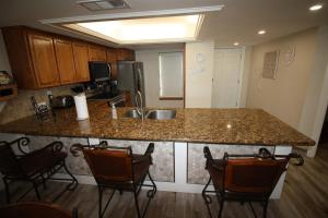 a kitchen with a counter with chairs around it at 12th Floor Penthouse Beachfront, Large Balcony, Amazing Views, 3 Pools, Tennis in South Padre Island