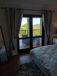 a bedroom with a bed and a view of a balcony at Sunset View in Somerset West
